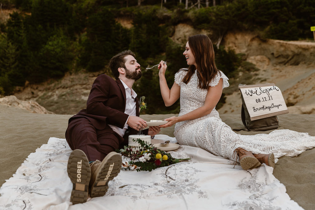 A couple feeds each other cake during their Samuel H Boardman State Park Elopement