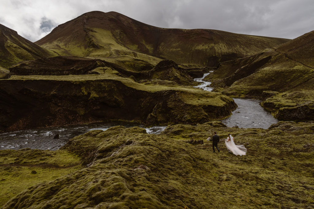 A couple walks to their ceremony location during their Iceland elopement