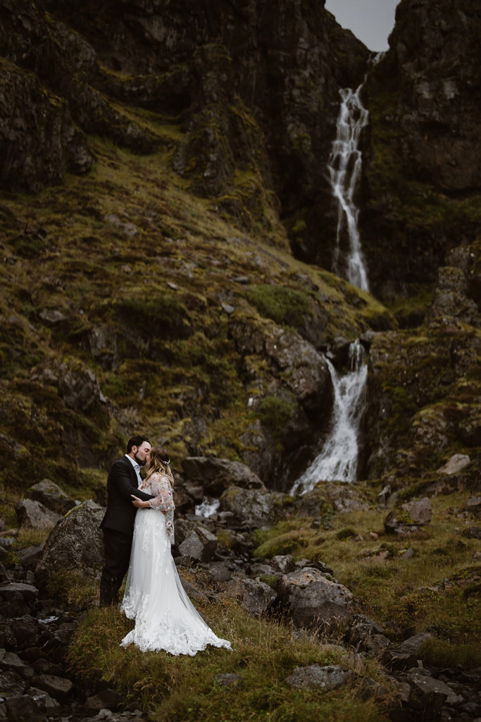 A couple kisses in front of a waterfall in Iceland