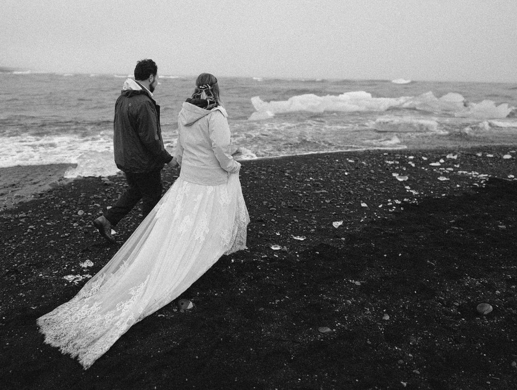 A couple walks on Diamond Beach during their Iceland Elopement