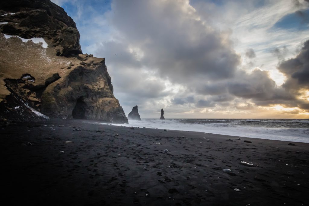 iceland black sand beach with sunset in the background