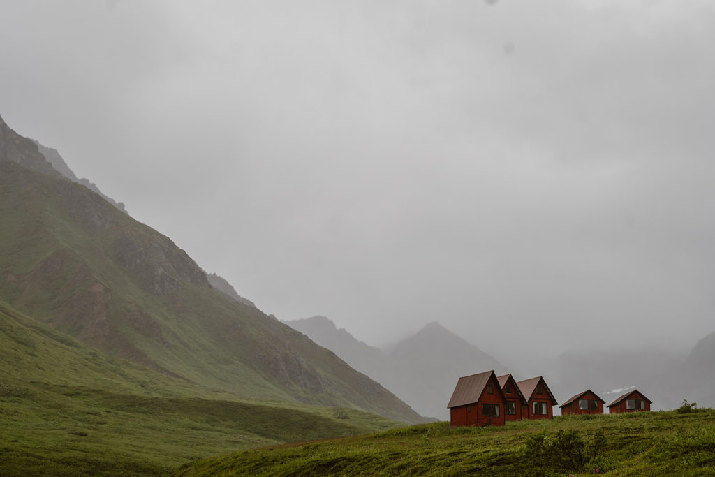 Small little huts on a green hill in Alaska