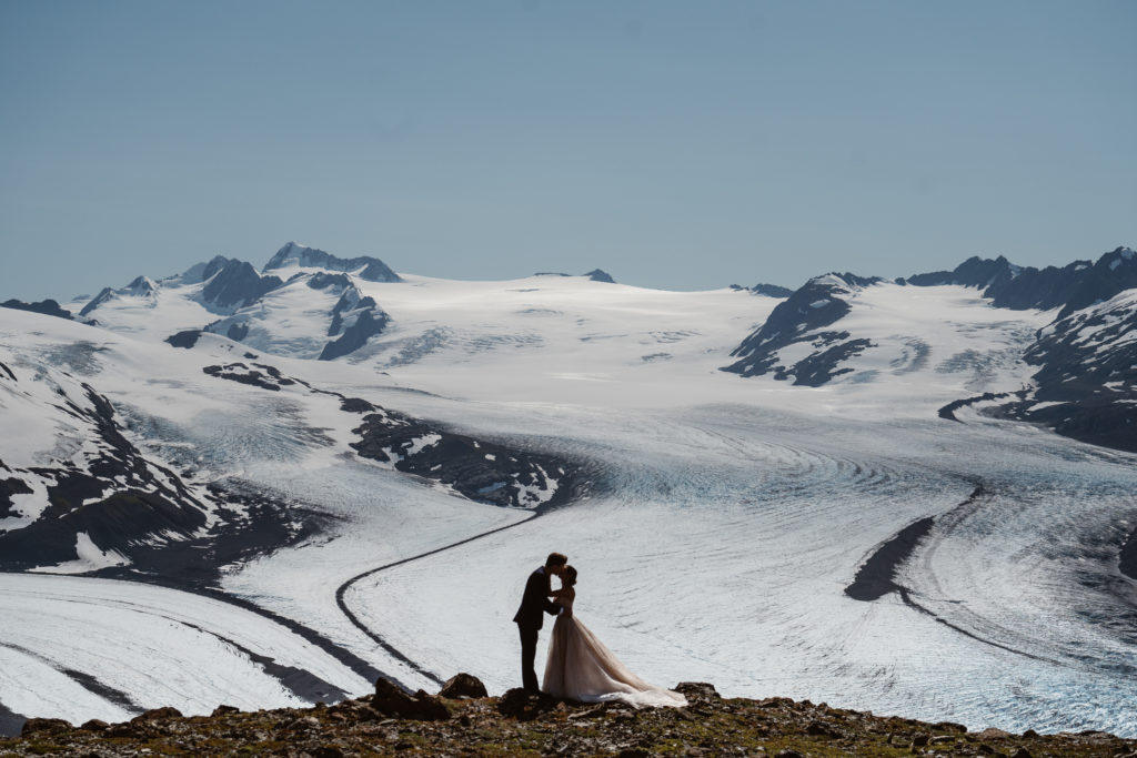 A couple kisses at their Alaska elopement.