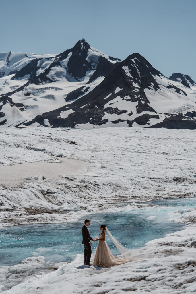 A couple reads their wedding vows at their Alaska elopement.