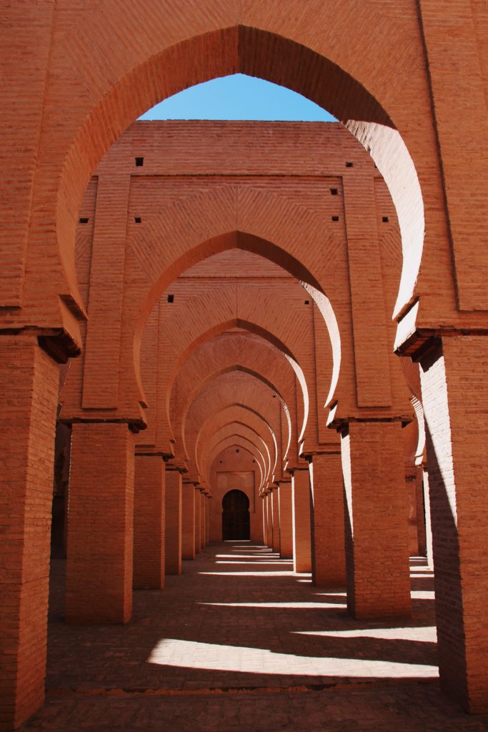 Circular pink-and-tan arches line a hallway in Morocco