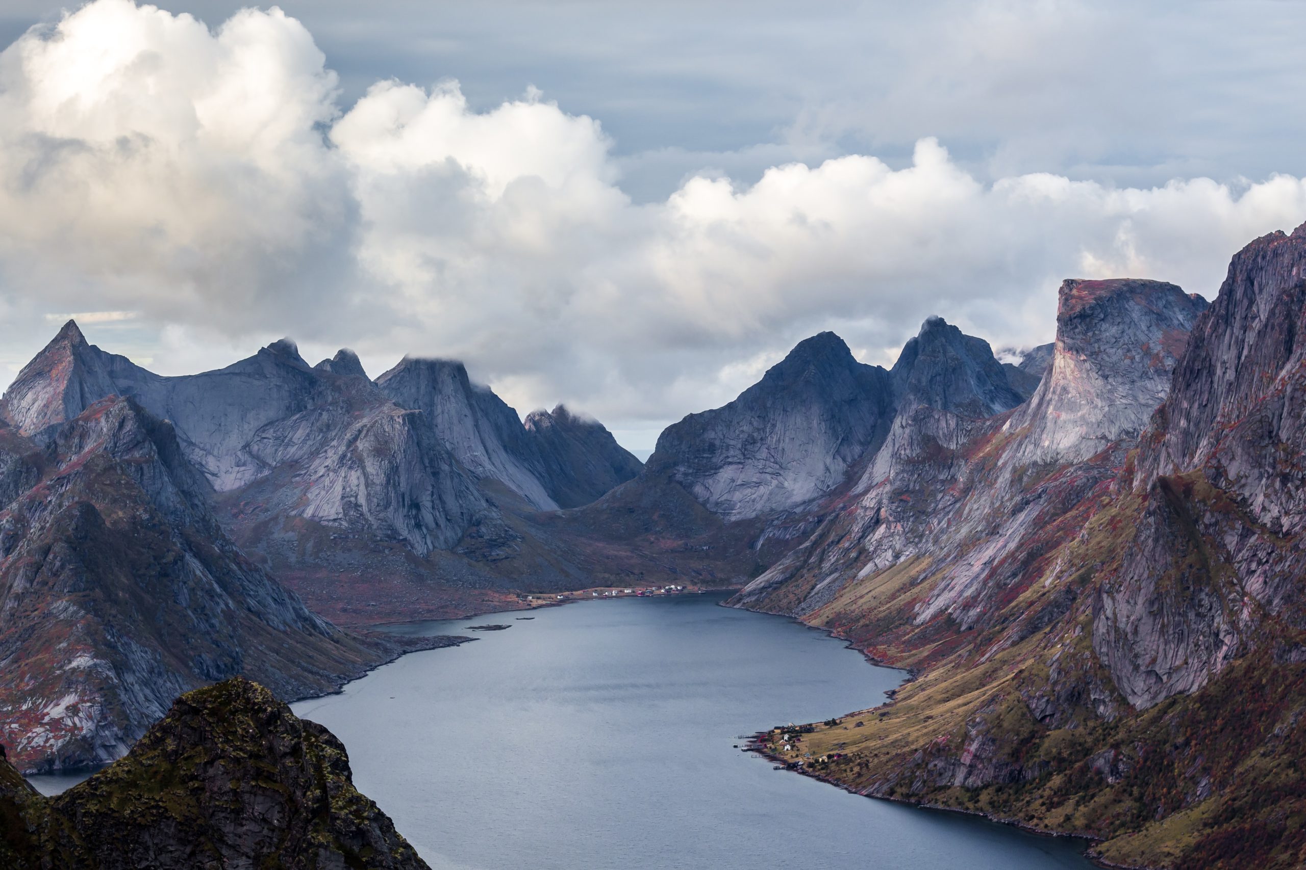 Towering mountains surround a lake in a valley in Norway