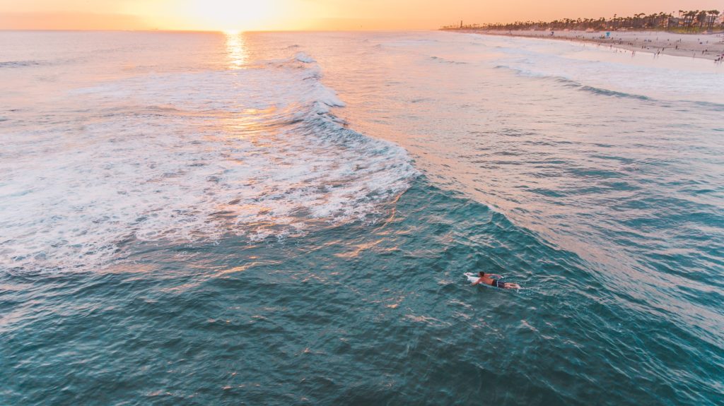Sun sets as surfers ride the waves in Huntington Beach